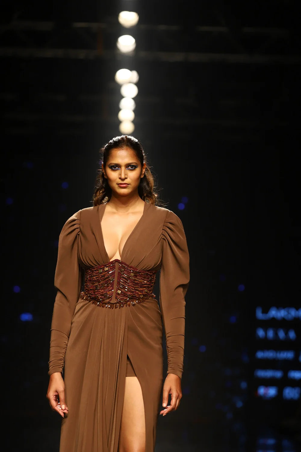 Dark tan luxury gown featuring deep V-neckline and hand-embellished corset bodice