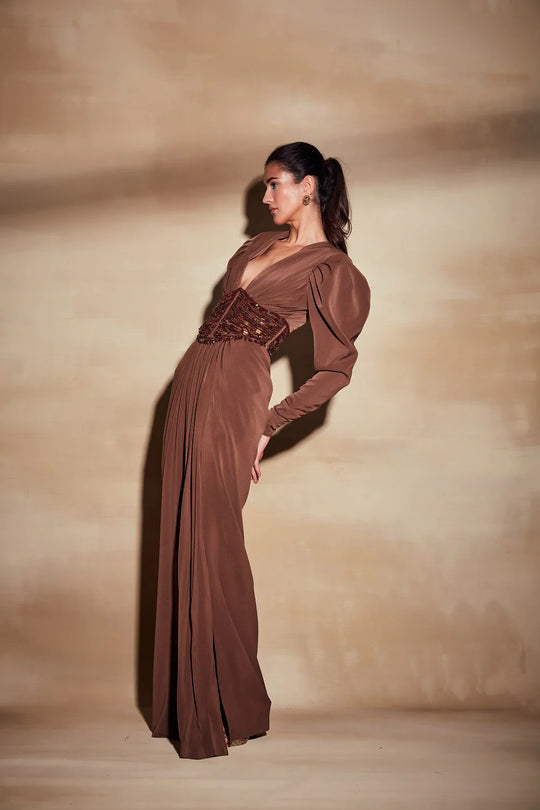 Dark tan long dress with deep neckline and fitted waist from side view